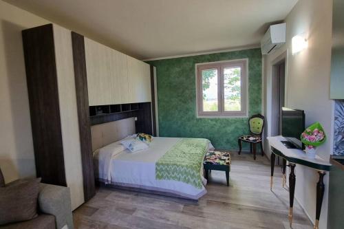 una camera da letto con pareti verdi, un letto e una scrivania di appartamento Margherita a Crespina