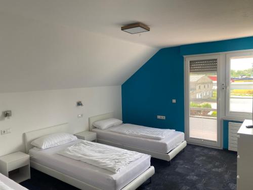 ein Schlafzimmer mit 2 Betten und einer blauen Wand in der Unterkunft Ferienwohnungen zur Elz in Kappel-Grafenhausen