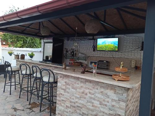 eine Bar mit Hockern und einem TV an einer Backsteinwand in der Unterkunft Işıl Suit Apart Otel in Dalyan