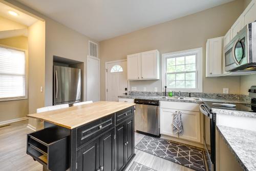 a kitchen with white cabinets and a wooden counter top at Wilmington Getaway Near Riverwalk and Downtown! in Wilmington