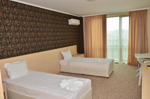 プリモルスコにあるLa Piazza Primorsko Rooms & Apartmentsのベッド2台と窓が備わるホテルルームです。