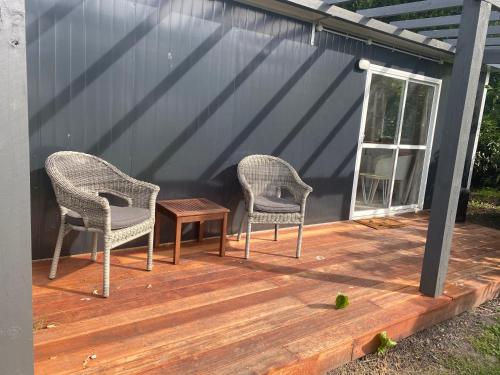 two chairs and a table on a wooden deck at Riverside in Clive in Clive