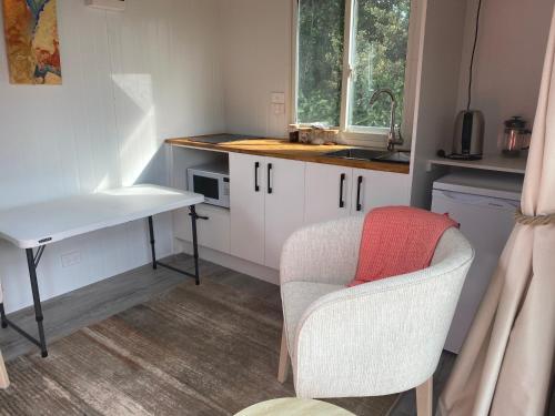 een keuken met een stoel, een bureau en een wastafel bij Riverside in Clive in Clive