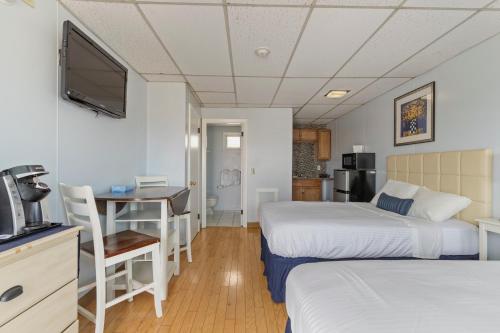 a hotel room with two beds and a desk and a television at Mt Royal Motel in Old Orchard Beach