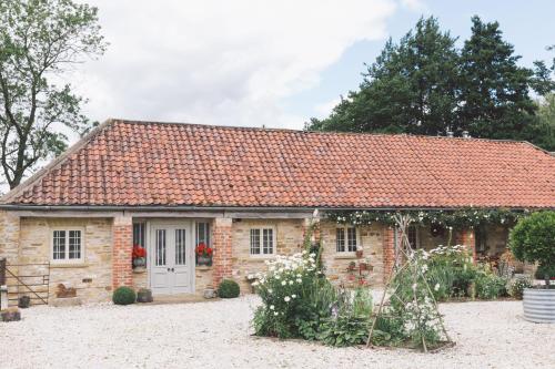 a stone cottage with a red roof at Seaves Mill in York