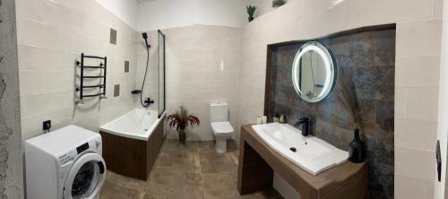 a bathroom with two sinks and a washing machine at Дом для отдыха на Фонтане in Odesa