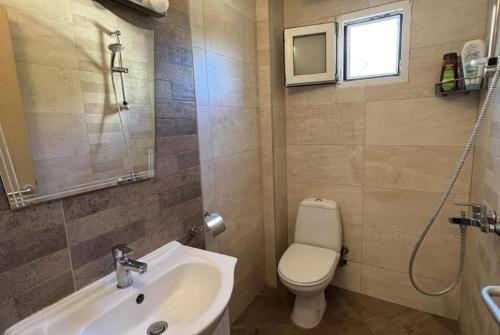 a bathroom with a sink and a toilet and a window at 2-Стаен Апартамент in Ignatievo