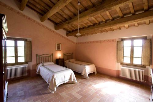 a bedroom with two beds and two windows at Villa Il Cigno in Brisighella