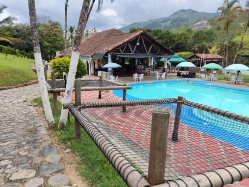 a pool at a resort with a restaurant at Hosteria Puerta del Nus in Cisneros