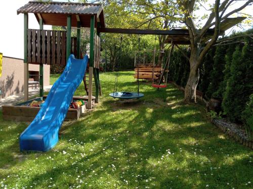 a playground with a blue slide in a yard at Apartament Kapi in Kalwaria Zebrzydowska