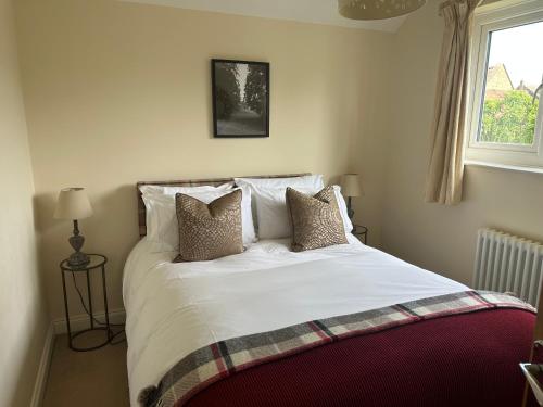 a bedroom with a white bed with pillows and a window at Scalby Grove Cottage in Scalby