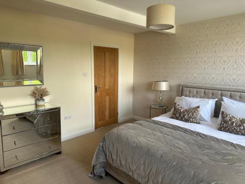 a bedroom with a bed and a dresser and a mirror at Scalby Grove Cottage in Scarborough