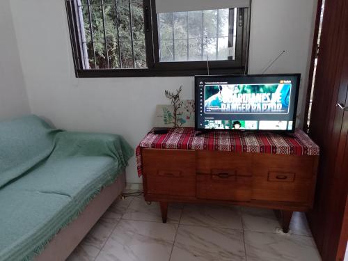 una habitación con TV en un tocador y una cama en El campo en 