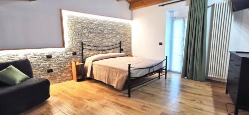 - une chambre avec un lit et un mur en briques dans l'établissement Dietro le mura, à Casoli