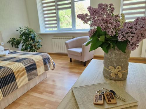 una stanza con un vaso di fiori viola su un tavolo di Villa ZENKO a Lviv