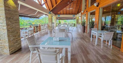 ein Restaurant mit Tischen und Stühlen in einem Gebäude in der Unterkunft Vista del Campo Country Club & Villas in Jarabacoa