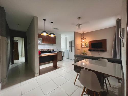 a kitchen and living room with a table and chairs at Hotel APART Zuccolotto 202 in Aracruz