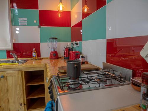 a kitchen with a stove top oven next to a counter at Cabañas La Lila in Huinganco