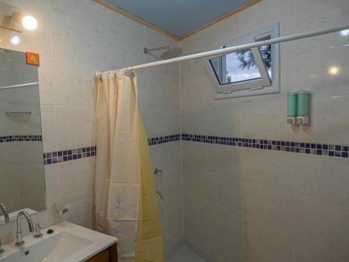 a bathroom with a shower curtain and a sink at Cabañas La Lila in Huinganco