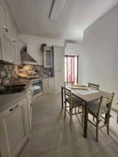 cocina con mesa, mesa y sillas en Il Pizzuto - Appartamento da Nonno Dino, en Bernalda