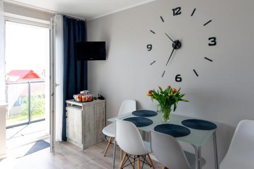 a dining room with a table and a clock on the wall at REWA pokoje gościnne in Rewa