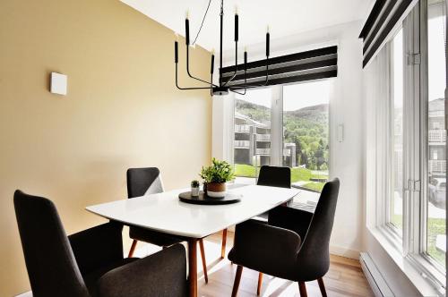 斯托漢的住宿－26#41 Chemin du Hameau (studio)，一间配备有白色桌子和黑色椅子的用餐室