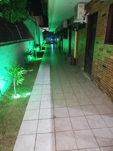 an empty alley at night with green lights at Pousada Jasmine in João Pessoa