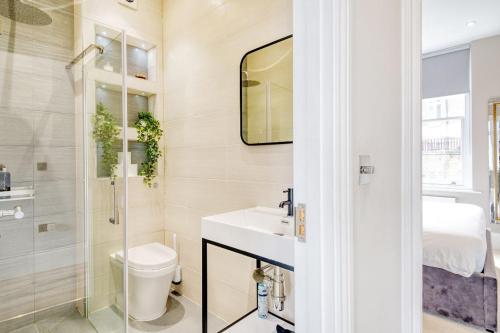 a bathroom with a sink and a toilet and a mirror at Elegant 1 bed apartment- Hampstead Village in London