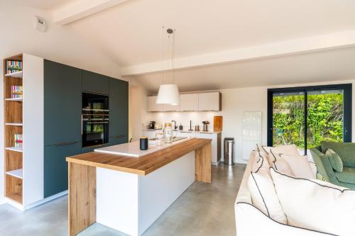 an open kitchen and living room with a counter and chairs at Villa confortable à Seignosse avec piscine privée in Seignosse