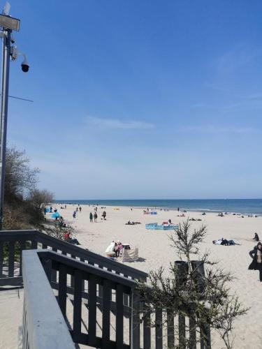 a beach with people on the sand and the ocean at WiLLA APART in Władysławowo