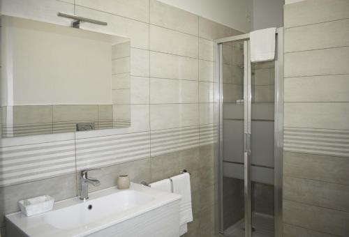 uma casa de banho com um lavatório e uma cabina de duche em vidro. em Marcelli Mare Camere Nel Conero em Numana