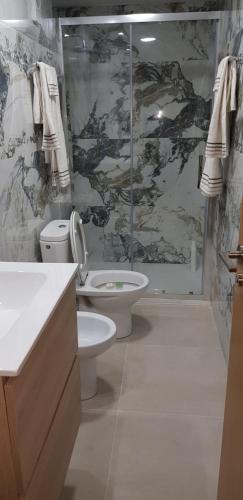 a bathroom with a toilet and a glass shower at Habitación Tranquila, Agradable cerca de Valencia en Vivienda Compartida in Paterna