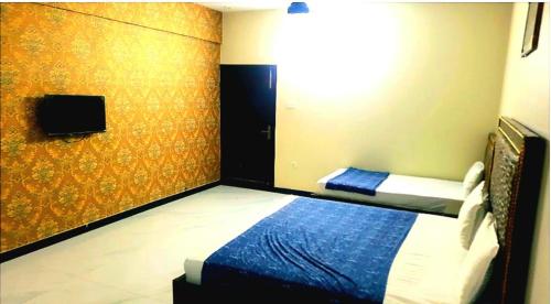 una camera con letto in una stanza con TV di Hotel Sky Inn Gulsan a Karachi