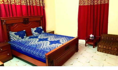 a bedroom with a bed and red curtains at Hotel Sky Inn Gulsan in Karachi