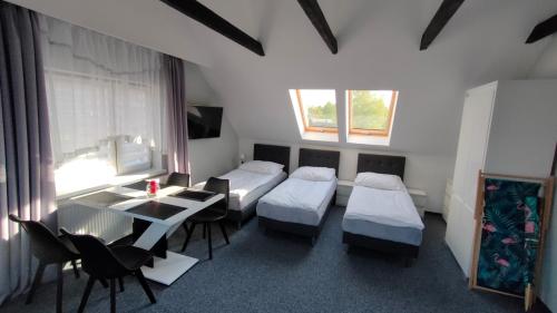 a room with three beds and a table and chairs at wczasypustkowo in Pustkowo
