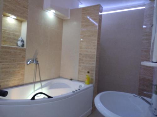 a bathroom with a tub and a toilet and a sink at Z&G Apartment in Bitola
