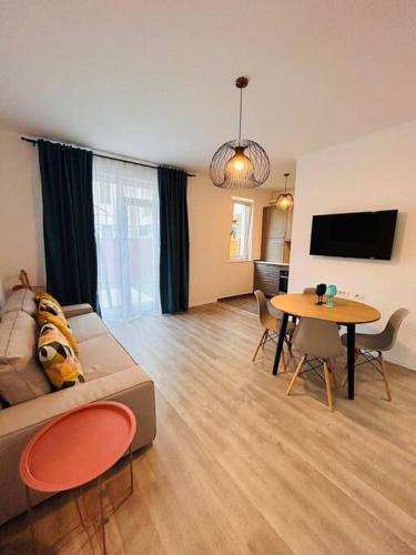 - un salon avec un canapé et une table dans l'établissement Apartment #12lunipebega Timisoara, à Timişoara