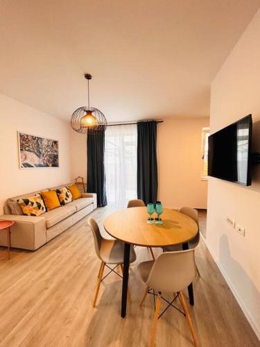 - un salon avec une table et un canapé dans l'établissement Apartment #12lunipebega Timisoara, à Timişoara