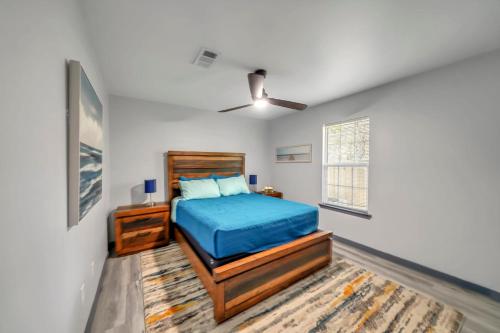 - une chambre avec un lit bleu et une fenêtre dans l'établissement Bungalow 1mile from Beach TVs Games Backyard, à Navarre