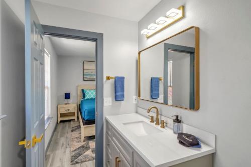 La salle de bains est pourvue d'un lavabo et d'un miroir. dans l'établissement Bungalow 1mile from Beach TVs Games Backyard, à Navarre