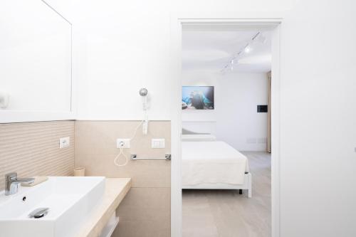 索拉納斯的住宿－Istedda Boutique Hotel，浴室设有床、水槽和镜子