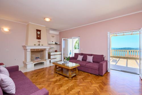 a living room with two purple couches and a fireplace at Helton SeaView Apartments in Orasac