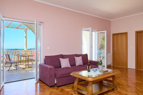 a living room with a purple couch and a table at Helton SeaView Apartments in Orasac