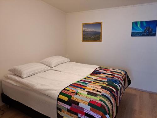 Un dormitorio con una cama con una colcha colorida. en Apartment in the center, en Húsavík