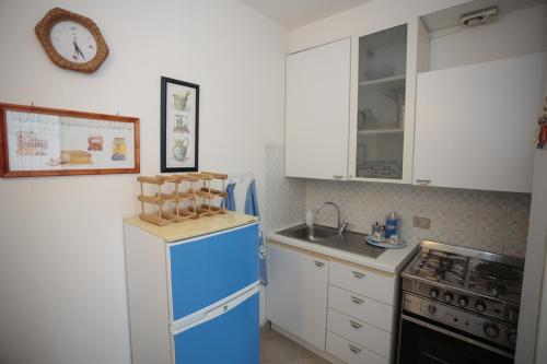 cocina con nevera azul y fregadero en Appartamento Gardenhouse, en Aci Trezza