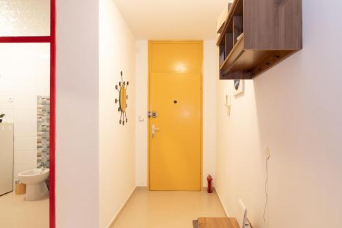 a yellow door in a room with a toilet at Apartment LilyM in Rovinj