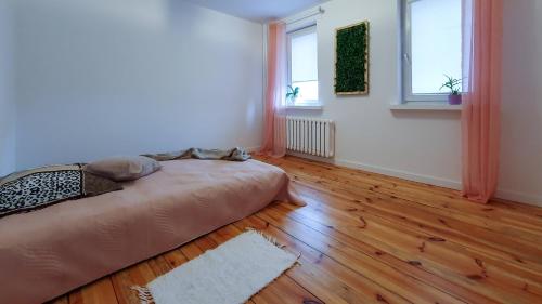 1 dormitorio con 1 cama y suelo de madera en Gdańsk Zako! en Gdansk