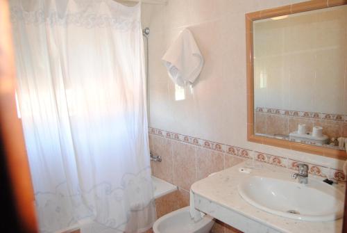 a bathroom with a white shower curtain and a sink at Hotel Riveiro in Sanxenxo