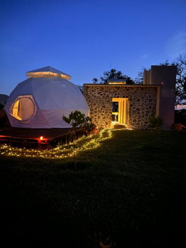 ein Zelt in einem Hof in der Nacht mit Lichtern in der Unterkunft Glamping Xochitepec in Xochitepec