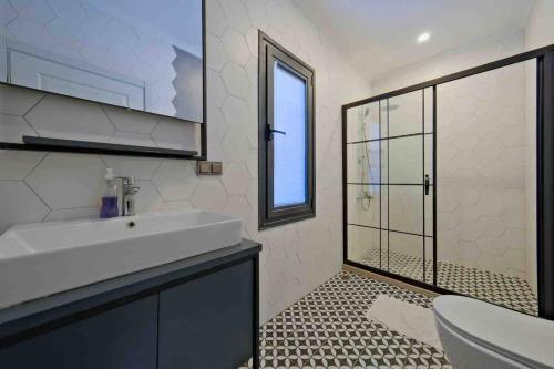 a bathroom with a sink and a toilet and a window at Kıryaman Villa 
